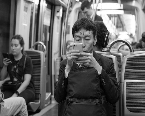 Commuter using smartphone thoughtfully on public transport